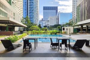 a patio with a table and chairs and a pool at Lovely CondoStay Cebu T2-25 in Cebu City