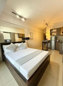 a large bed in a room with a kitchen at Lovely CondoStay Cebu T2-25 in Cebu City