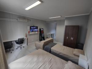 a hospital room with two beds and a television at Apto Studio 202 centro floripa in Florianópolis