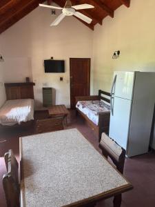 a living room with two beds and a refrigerator at Cabañas de la Colina in Villa General Belgrano