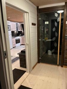 a kitchen with a shower and a glass door at Cottage on the shore of Ivalojoki in Inari +18 photos