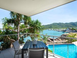 Nelly BayにあるGrand Mercure Apartments Magnetic Islandの水辺の景色を望むバルコニー(テーブル、椅子付)