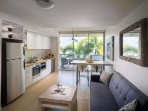 Nelly BayにあるGrand Mercure Apartments Magnetic Islandのソファとテーブルのあるキッチンとリビングルーム
