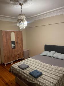 a bedroom with a bed and a chandelier at Şehrin merkezinde evinizde hissedeceğiniz oda in Konak