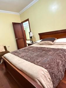 a bedroom with a large bed and a mirror at House Loft Loja in Loja