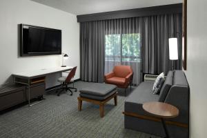 Habitación de hotel con sofá, escritorio y ordenador en Courtyard Williamsburg - Busch Gardens, en Williamsburg