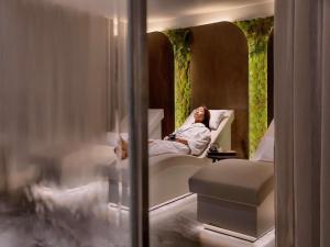 a woman laying in a bed in a hotel room at Sofitel Auckland Viaduct Harbour in Auckland
