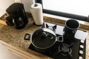 a stove top with a pot and pans on a counter at Departamento en Planta Baja ideal para Valle de Catrinas in Atlixco