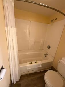 Un baño con bañera blanca y un inodoro. en Frontier Lodge, en Lander 34 fotos más