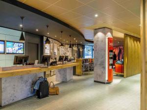 a restaurant with a bar with a luggage bag at Ibis Hamburg City in Hamburg