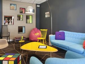 Una sala de estar con un sofá y sillas y una mesa. en ibis Styles Roanne Centre Gare, en Roanne