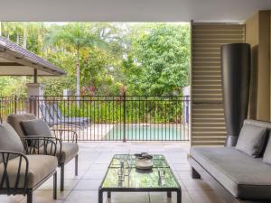 d'une terrasse avec un canapé, des chaises et une table. dans l'établissement Pullman Port Douglas Sea Temple Resort and Spa, à Port Douglas