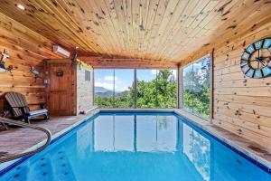 Una piscina en una casa de madera con un reloj en la pared. en Fall Family Fun-Pool in Cabin-View-Games-Hot Tub, en Sevierville