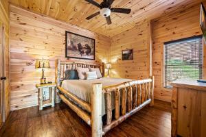 Un dormitorio con una cama en una cabaña de troncos en Fall Family Fun-Pool in Cabin-View-Games-Hot Tub, en Sevierville 50 fotos más