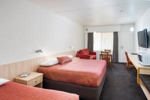 um quarto de hotel com duas camas e uma televisão em Box Hill Motel em Burwood