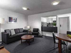 a living room with a couch and a table at The Sebel Brisbane in Brisbane