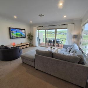 a living room with two couches and a television at 19th Hole Golf, Wine & Sea in Normanville