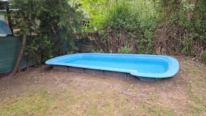 a blue tub sitting in the grass in a yard at Hospedaje La Cabaña in San Miguel del Monte +5 photos