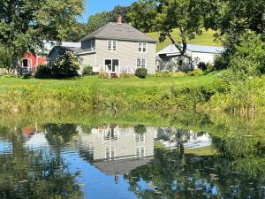 a house sitting next to a body of water at Rainbow Ridge Farms in Onalaska