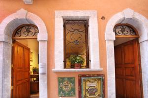 Casa Antico Borgo Cuseni في تاورمينا: مدخلين مقوسين لمبنى ذو بابين