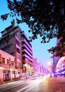 a city street with buildings and cars on the road at Guang Dong Hotel in Guangzhou