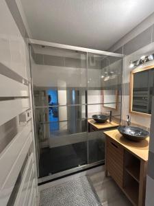 a bathroom with two sinks and a glass shower at T2 cosy, calme et 2 Parking privé avec Piscine in Toulouse
