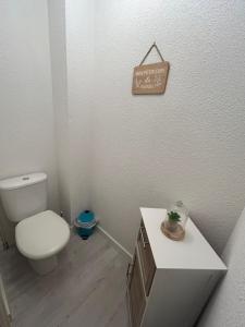 a bathroom with a toilet and a sign on the wall at T2 cosy, calme et 2 Parking privé avec Piscine in Toulouse +6 photos