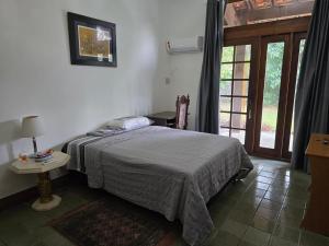 a bedroom with a bed and a table and a window at Wonderful lakefront house in a luxury condominium - Ananindeua in Ananindeua