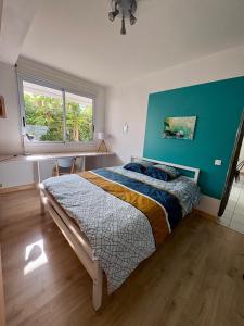 a bedroom with a bed and a blue wall at Nouméa F2 jardin et clim, proche plages in Noumea