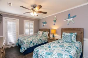 Un dormitorio con dos camas y un ventilador de techo. en Sutton House, en Edisto