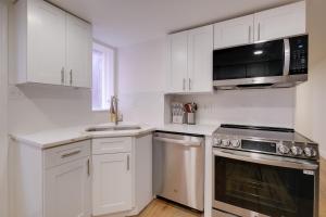 a kitchen with white cabinets and a sink and a microwave at Central DC Location! Urban Oasis in Logan Circle in Washington