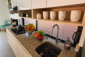 a kitchen counter with a sink and fruits and vegetables in baskets at Departamento en Planta Baja ideal para Valle de Catrinas in Atlixco