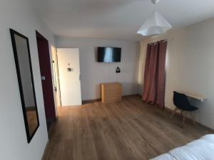 a bedroom with a bed and a television on the wall at Notre Dame d'Orgemont - Rose 3 in Argenteuil