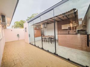 an open kitchen and dining area of a house with glass walls at Casa em bairro nobre + 3 quartos com ar e 2 vagas in Ourinhos