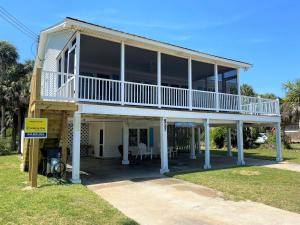 a large house with a balcony on top of it at Sand In My Shoes in Edisto Island