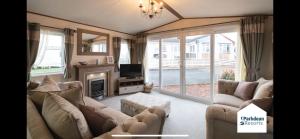 a living room with a couch and a tv at Fabulous seaside caravan getway at Cayton Bay in Scarborough
