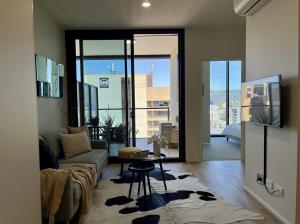 a living room with a couch and a table at Level 18 Heart of Adelaide with Gym, City Views in Adelaide