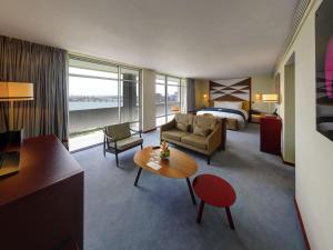 アビジャンにあるSofitel Abidjan Hotel Ivoireのベッドとリビングルームがあるホテルの部屋