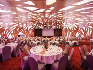 アビジャンにあるSofitel Abidjan Hotel Ivoireの白いテーブルと椅子、スクリーンが備わる宴会場 +245枚の写真