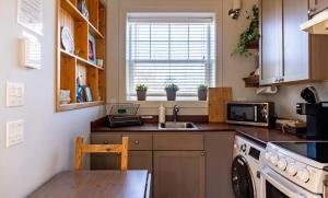 eine kleine Küche mit Spüle und Mikrowelle in der Unterkunft Sea Breeze Cottage #1 in Ocean Shores + 4 Fotos