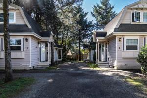 ein weißes Haus mit einer Auffahrt davor in der Unterkunft Sea Breeze Cottage #1 in Ocean Shores