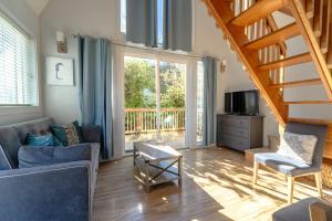 ein Wohnzimmer mit einem blauen Sofa und einer Treppe in der Unterkunft Sea Breeze Cottage #1 in Ocean Shores