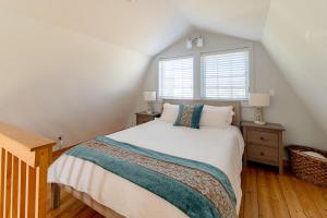 ein Schlafzimmer mit einem weißen Bett und einem Fenster in der Unterkunft Sea Breeze Cottage #1 in Ocean Shores