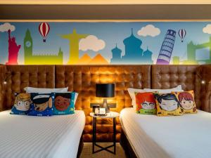 a bedroom with two beds with cartoon characters on the wall at Pullman Sao Paulo Guarulhos Airport in Guarulhos