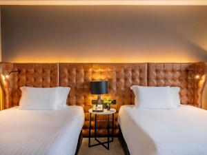 two beds sitting next to each other in a room at Pullman Sao Paulo Guarulhos Airport in Guarulhos