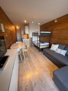 a living room with a couch and a table at appartement cozy au pied des pistes in Le Corbier