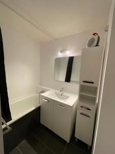 a small bathroom with a sink and a bath tub at appartement cozy au pied des pistes in Le Corbier