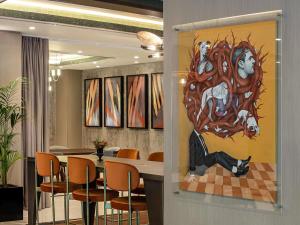 un comedor con una gran pintura en la pared en The Artisan Hotel Istanbul - MGallery Collection, en Estambul