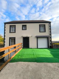 Una casa con un césped verde delante de ella. en Notre Dame d'Orgemont - Gris 5, en Argenteuil 8 fotos más