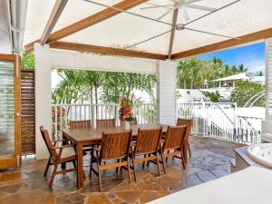 Un comedor con mesa y sillas de madera. en The Reef House Adults Retreat - Enjoy 28 Complimentary Inclusions, en Palm Cove
